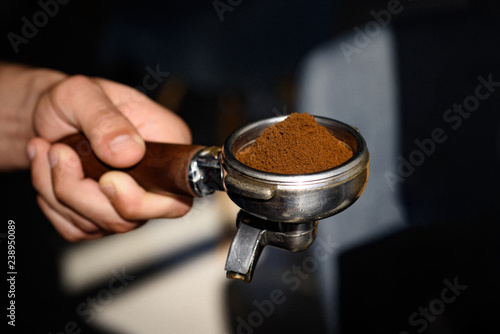 For true coffee connoisseurs. Coffee making in coffeehouse. Fresh ground coffee. Barista hold portafilter in hand. Barista brews espresso drink in cafe. Brewing coffee equipment