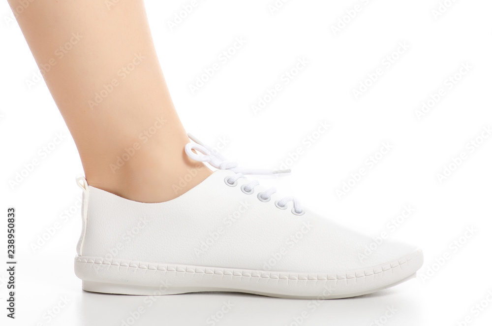 Female legs in white sneakers shoes beauty on white background. Isolation