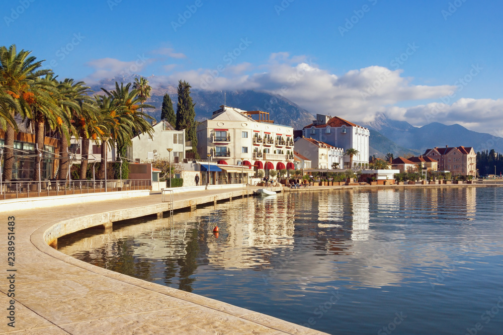 Beautiful Mediterranean landscape on sunny winter day. Montenegro, embankment of Tivat city and peaks of Lovcen mountain