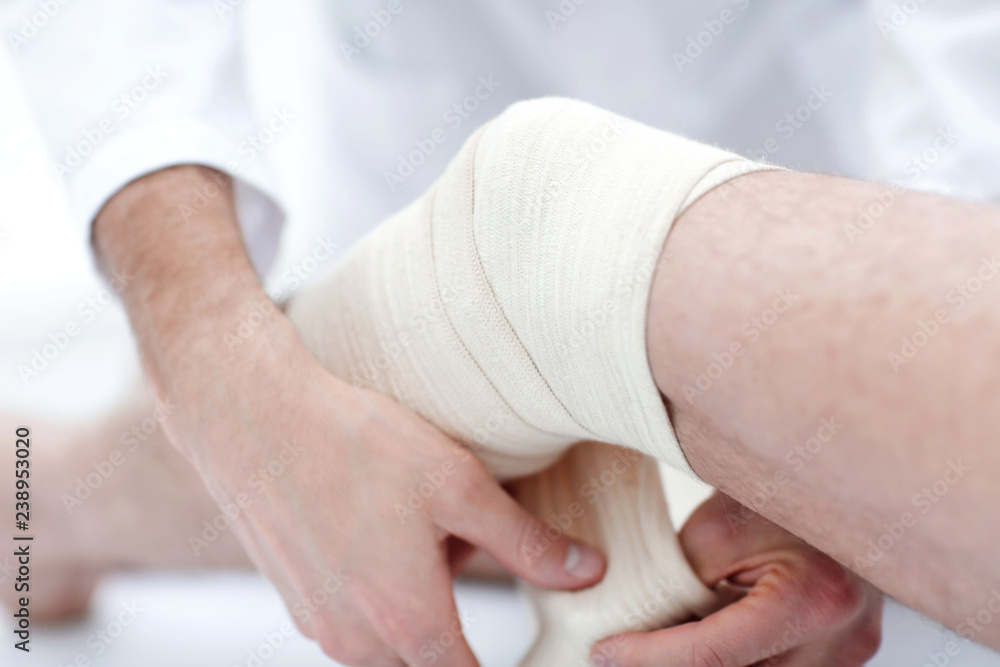closeup. doctor bandaging a patient's leg closeup. doctor bandaging a patient's leg