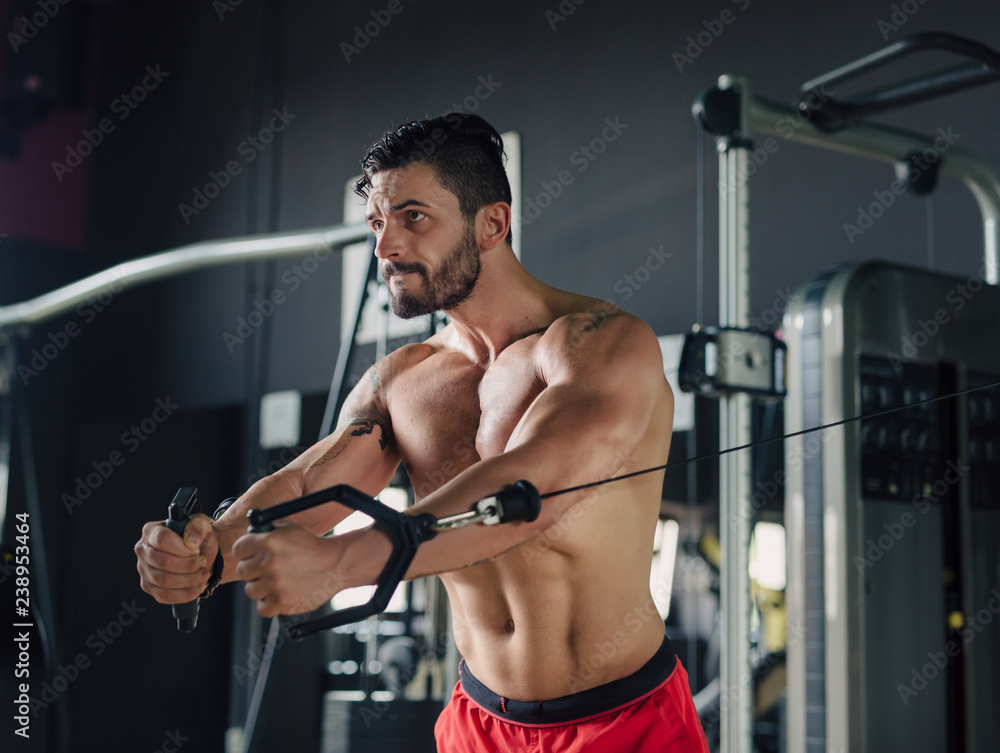 Strong man in the gym doing chest exercises
