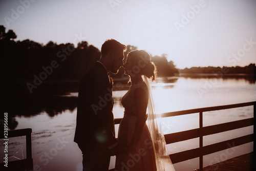 Silhouette of bride and groom against sunset sky