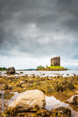 Mystical Castle Stalker on an islet on Loch Laich, cloudy day and low tide, scary and lost castle in Scotland, Great Britain photo