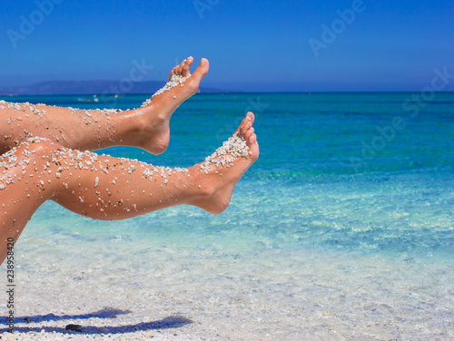 Closeup of female legs background of the turquoise sea