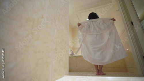 Young sexy brunette woman going to bathroom, undressing removing bathrobe and laying in bathtube with candles. Romantic dating. Slowmotion