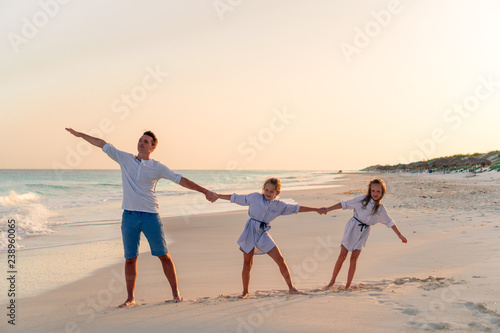 Family walking on white tropical beach on caribbean island © travnikovstudio