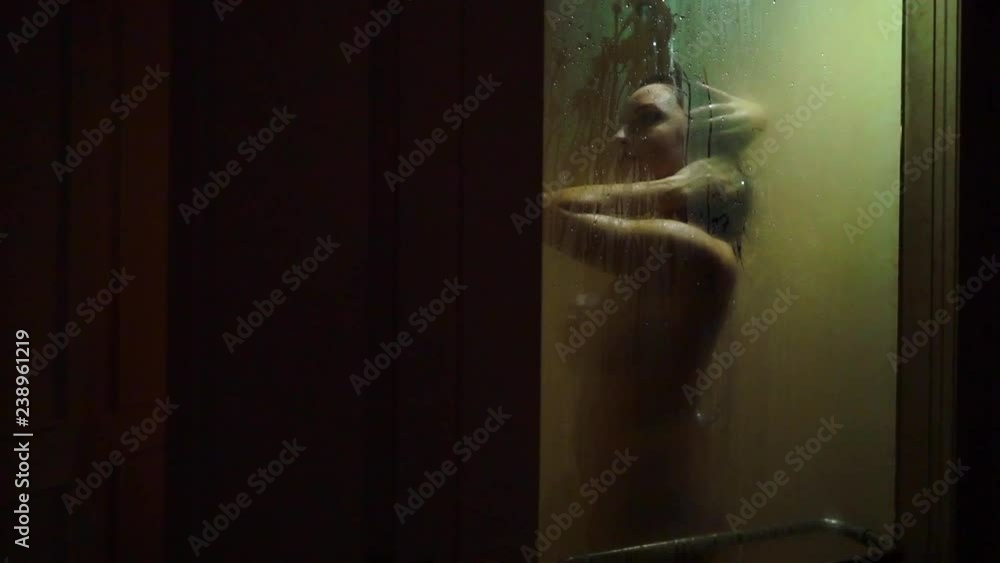 Young strong sexy woman taking shower naked. Silhouette slowmotion Young strong sexy woman taking shower naked. Silhouette slowmotion