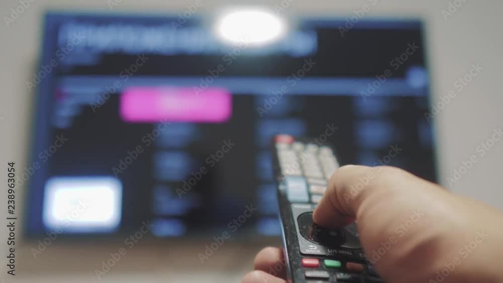 Smart tv with apps and hand. Male hand holding the remote control turn lifestyle off smart tv . man hand controls TV holding remote. TV concept internet online cinema Smart tv with apps and hand. Male hand holding the remote control turn lifestyle off smart tv . man hand controls TV holding remote. TV concept internet online cinema