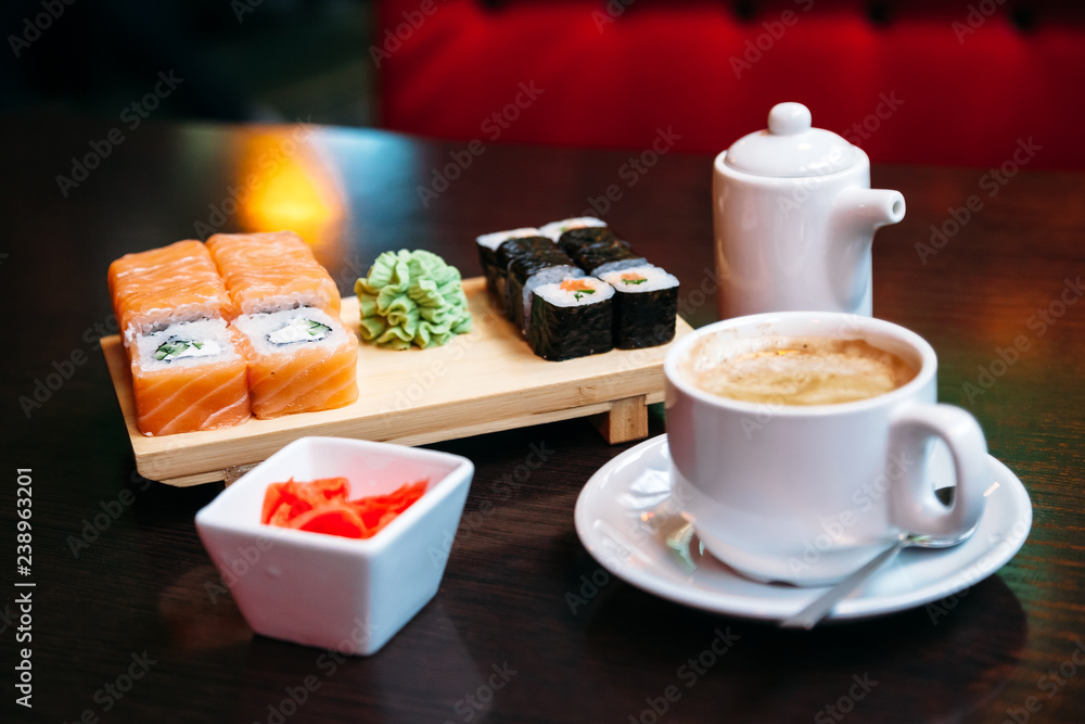 cup of coffee and sushi on table cup of coffee and sushi on table