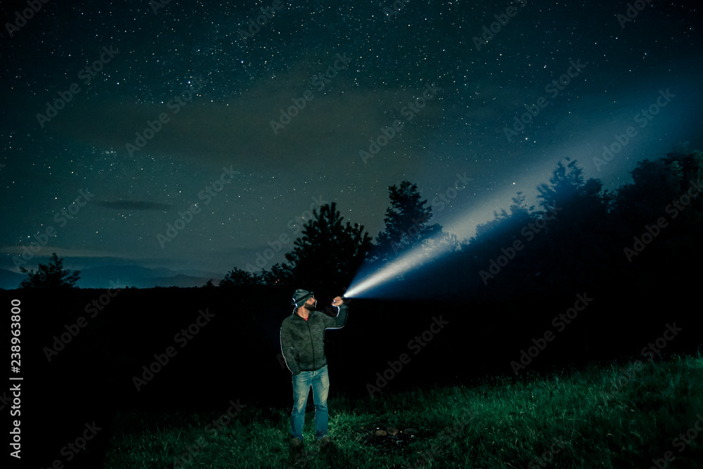 Man searching with flashlight in outdoor by night Man searching with flashlight in outdoor by night