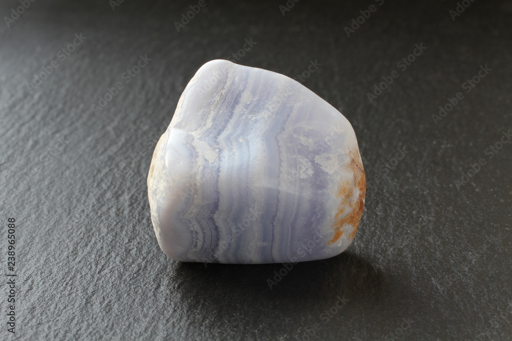 A blue agate stone on a black stone board A blue agate stone on a black stone board