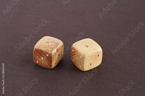 Two wooden dices with number one on the top on purple cloth