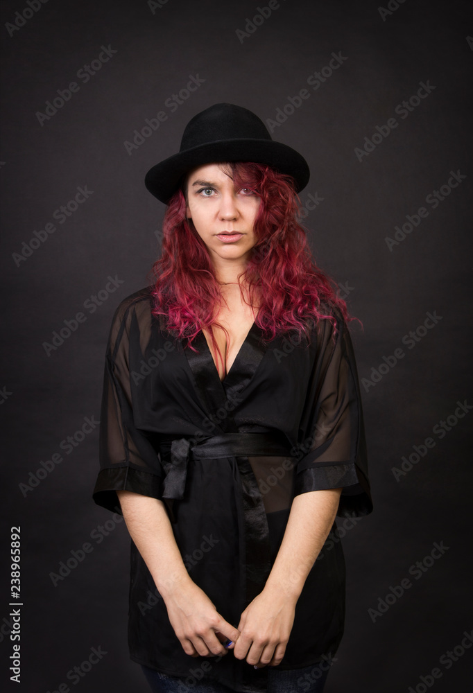 Emotional brunette in a hat with long hair posing in the Studio. Emotional brunette in a hat with long hair posing in the Studio.