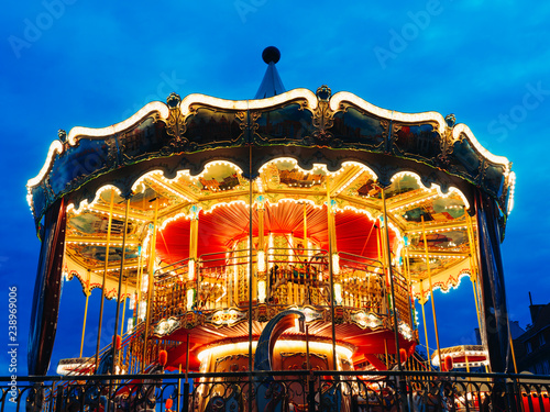 Carousel at an amusement park in the evening and night illumination