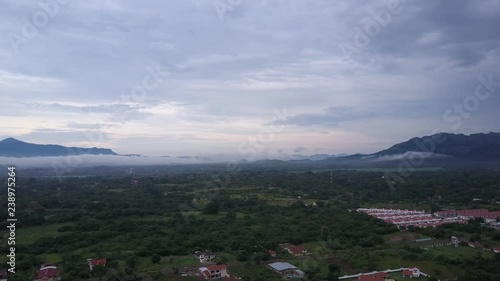 Aerial shot of tropical jungle, mountain, volcano, villas, sunset, sunrise. photo