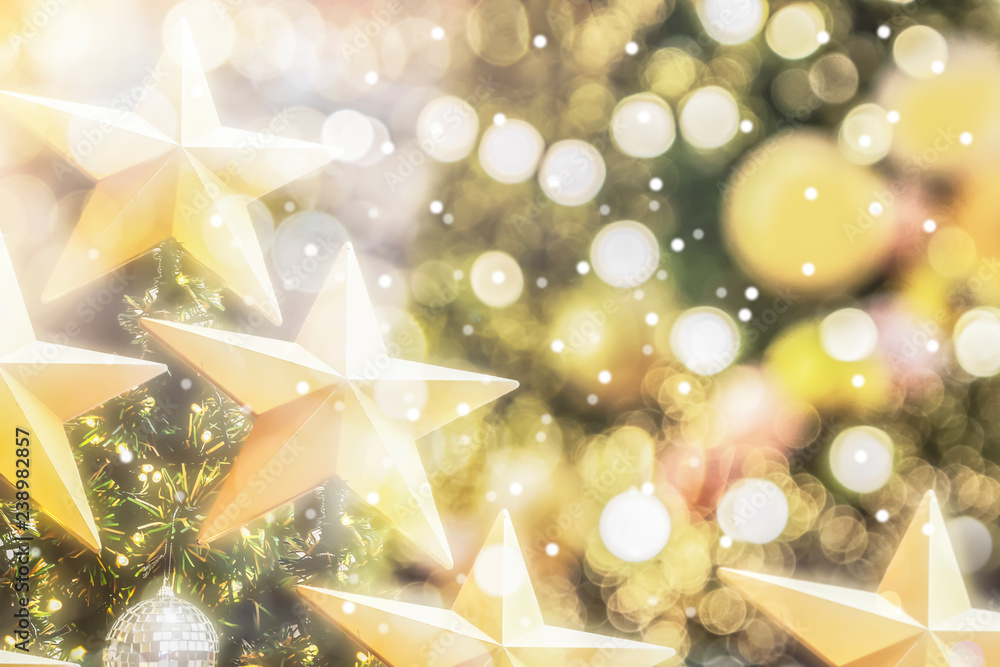 Christmas tree with blurry gold bokeh and golden star background with beautiful winter holiday soft white snow on bright and vivid shiny light. Christmas tree with blurry gold bokeh and golden star background with beautiful winter holiday soft white snow on bright and vivid shiny light.