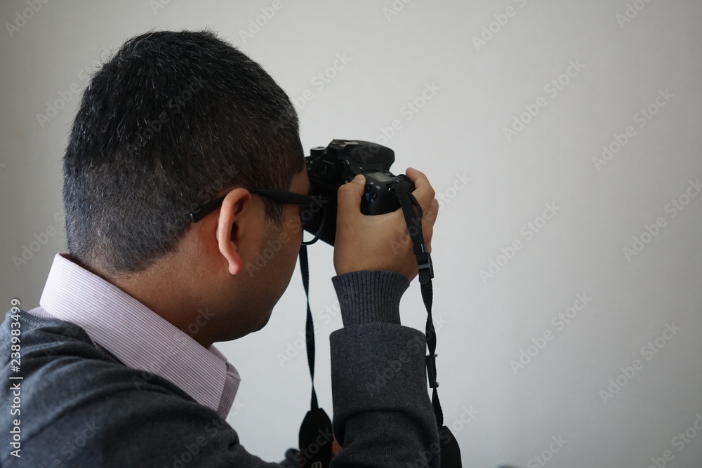 カメラを握りしめ写真を撮影するメガネをしたお洒落な男性アマチュアカメラマン Stock 写真 Adobe Stock