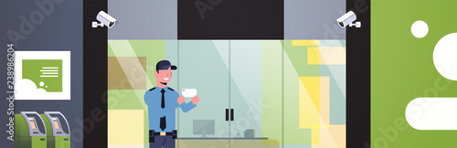 security guard mantaking selfie distracted at workplace entrance door business building exterior CCTV surveillance camera equipment flat horizontal