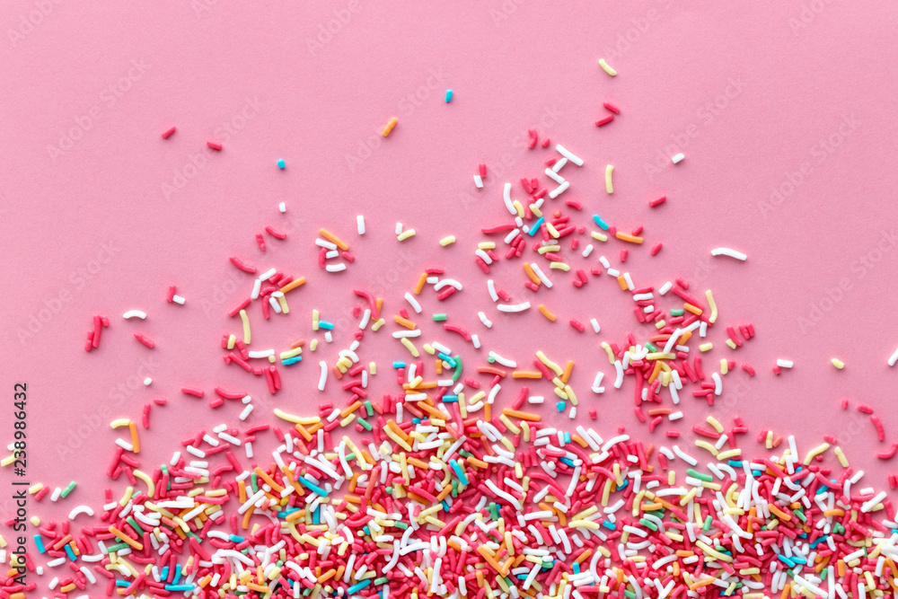 Colorful sprinkles on a pink background, top view with copy space Stock