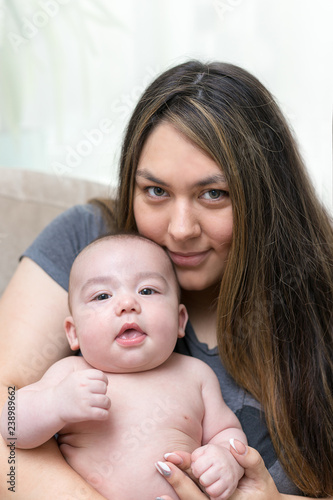 Mother is holding her newborn infant son