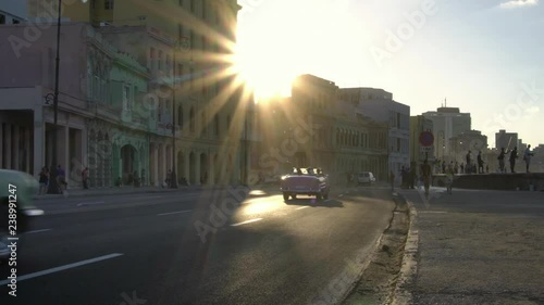 iconic classic 1950's American vintage convertible car driving on waterfront malecon street in old Havana, Cuba