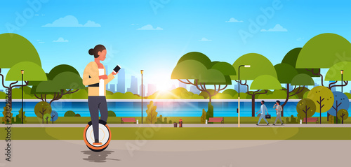 woman ride electric mono wheel using smartphone girl modern personal transport outdoor nature city urban park cityscape sunset background horizontal flat