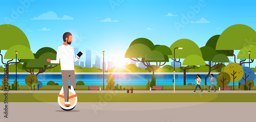 man ride electric mono wheel using smartphone guy modern personal transport outdoor nature city urban park cityscape sunset background horizontal banner flat