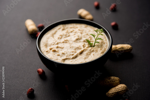 Healthy Peanut chutney made using Groundnut / Shengdana or mungfali. served in a small bowl with raw whole. Selective focus