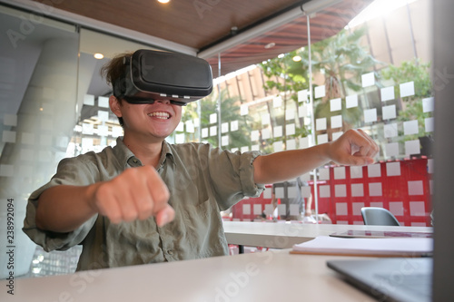 Worker Man wearing virtual reality goggles in modern office with relax time excited technology concept.
