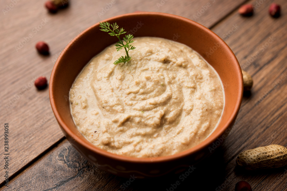 Healthy Peanut chutney made using Groundnut / Shengdana or mungfali. served in a small bowl with raw whole. Selective focus Healthy Peanut chutney made using Groundnut / Shengdana or mungfali. served in a small bowl with raw whole. Selective focus