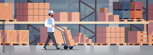 delivery man rolling cardboard box cargo trolley pushcart courier carrying parcels on hand truck warehouse room interior flat horizontal banner