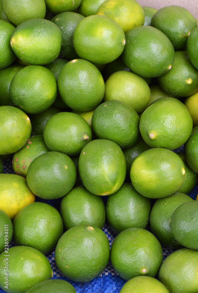 green fresh lemon lime texture background / pile of lime lemon for sale in the market green fresh lemon lime texture background / pile of lime lemon for sale in the market