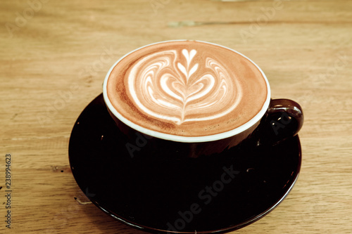 Hot coffee latte on a wooden table.