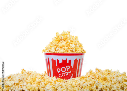Bucket of pop corn heaped high with popcorn and surrounded by the same, isolated on white background.