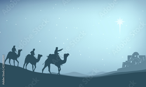 Christian Christmas Nativity Scene of baby Jesus in the manger with Mary and Joseph in silhouette surrounded by animals and the three wise men magi with the city of Bethlehem in the distance photo
