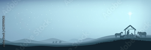 Banner Christian Christmas Nativity Scene of baby Jesus in the manger with Mary and Joseph in silhouette surrounded by animals and the three wise men magi with the city of Bethlehem in the distance