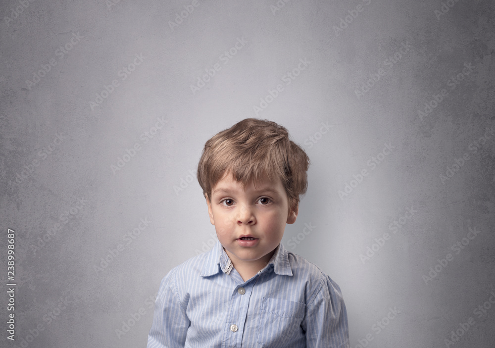 Fototapeta premium Adorable little boy portrait with empty grey wall background