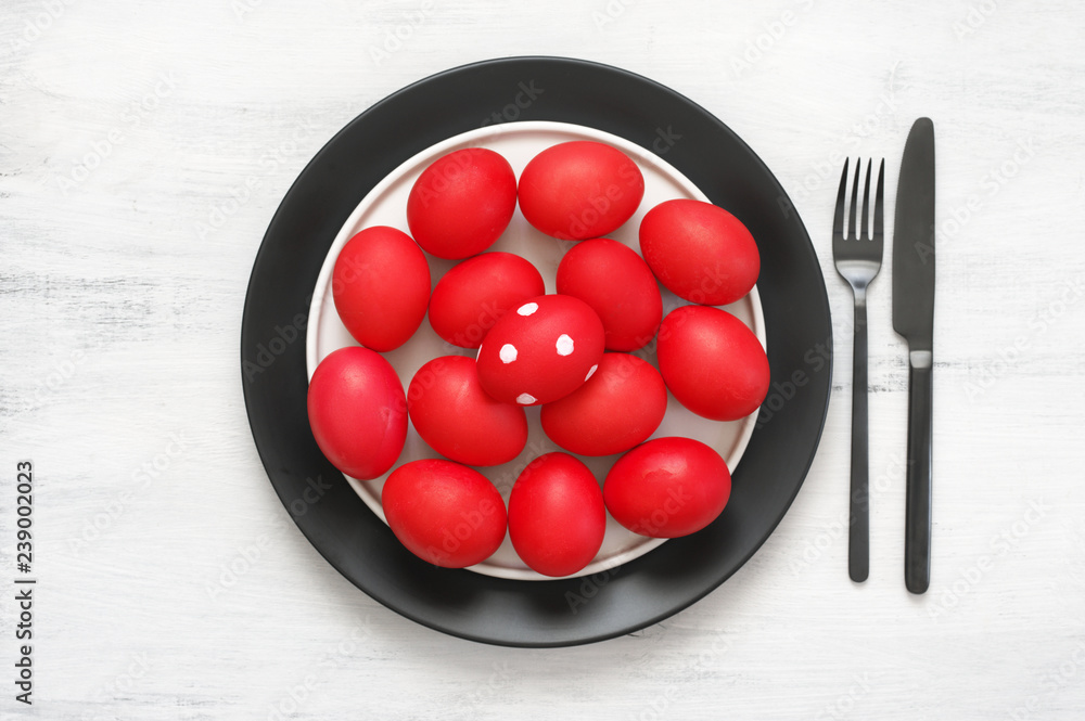 Red Easter eggs in plate with silverware Red Easter eggs in plate with silverware