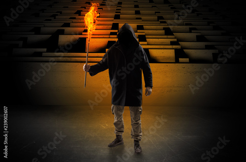 Ugly, aberrant man coming out from the labyrinth with burning flambeau on his hand
 photo