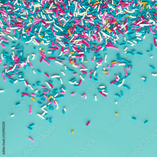 Colorful sprinkles on a blue background, top view with copy space