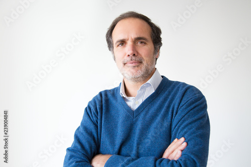 Confident middle aged man posing with crossed arms. Successful adult man with grey hair and beard. Isolated on white. Success concept