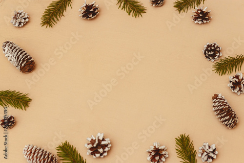 Wood christmas background with fir branches, fir and pine cones, top view, copyspace.