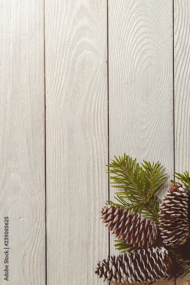 White wooden christmas background with fir branches and cones, top view, copyspace. White wooden christmas background with fir branches and cones, top view, copyspace.