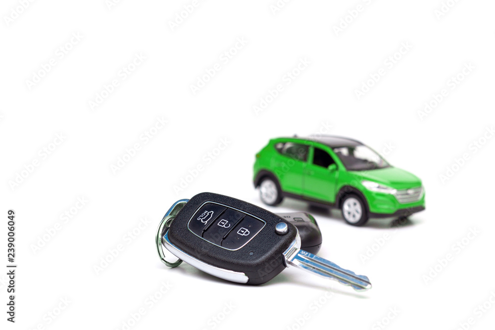 Keys to the new car on the background of the toy green car Keys to the new car on the background of the toy green car