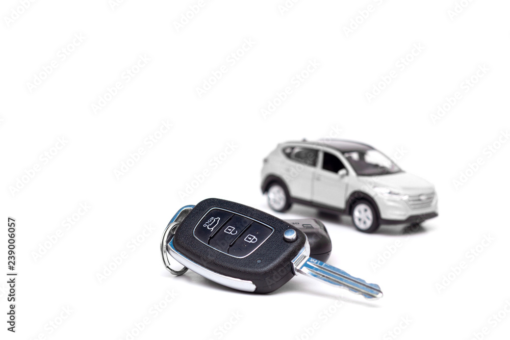 Keys to the new car on the background of the toy white car Keys to the new car on the background of the toy white car