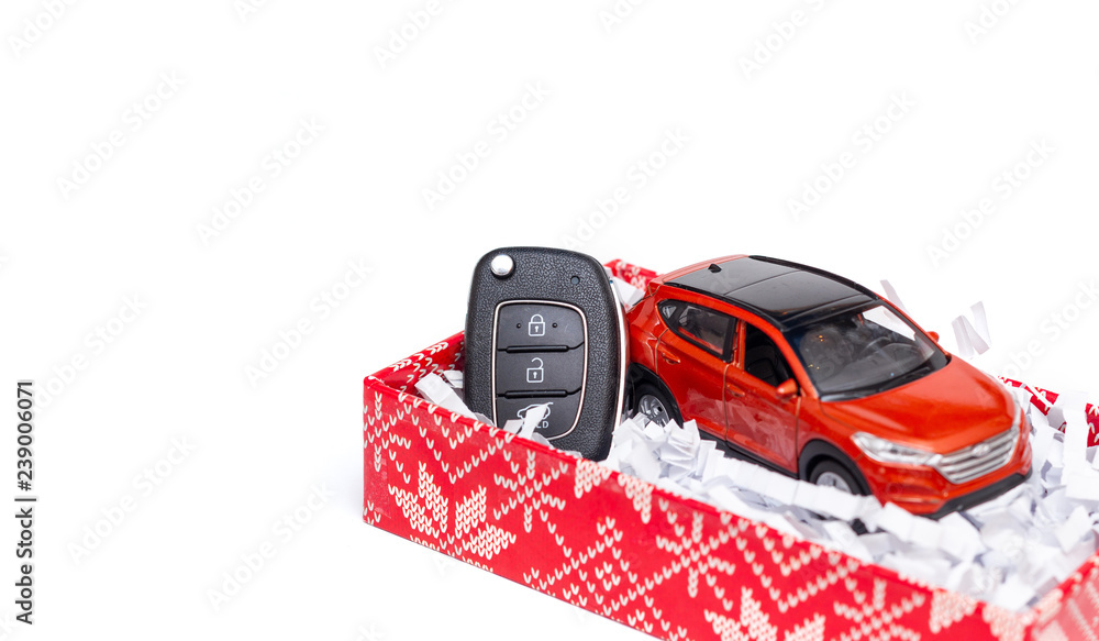 Car key with toy car in a red gift box on craft paper. The concept of a gift for Christmas, New Year, Valentine's Day