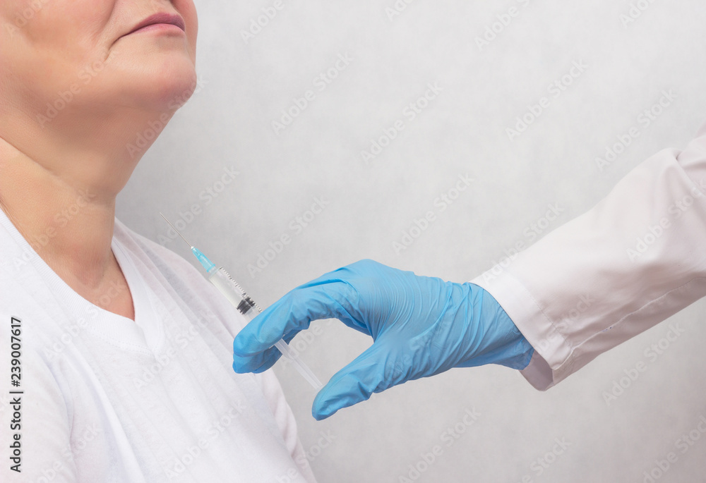 The doctor makes the woman puncture the thyroid gland to clarify the diagnosis, cancer, copy space The doctor makes the woman puncture the thyroid gland to clarify the diagnosis, cancer, copy space