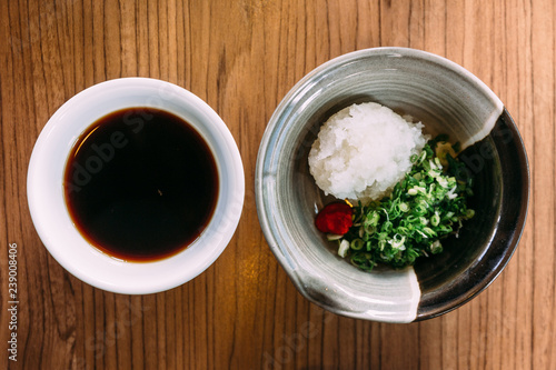 Top view of Shoyu Ponzu (Citrus soy sauce) with minced daikon and scallion.