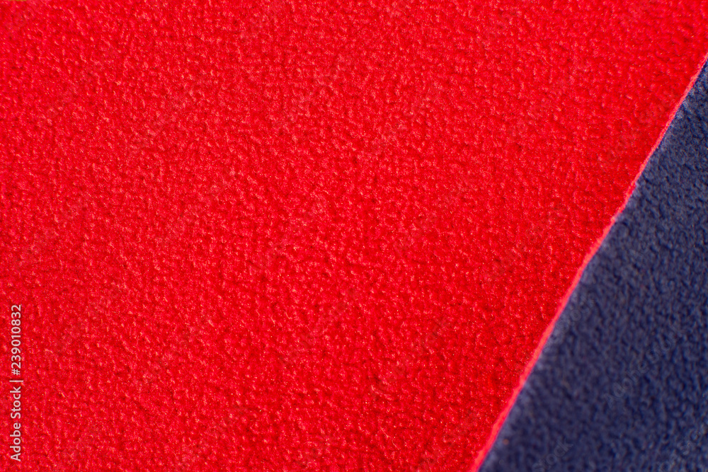 Fototapeta premium Texture of fleece fabric. Red and blue fleece fabric creates a textural background. Fabric fleece for sewing and design of fashionable clothes and objects.