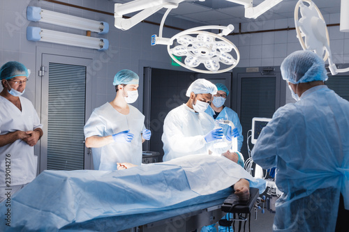 Medical Team Performing Surgical Operation in Bright Modern Operating Room. pre oxygenation for general anesthesia. Caucasian patient receives anaesthetic in hospital